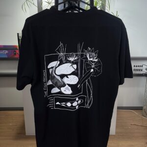 Black T-shirt hanging on rack with white abstract graphic of shapes and figures on front